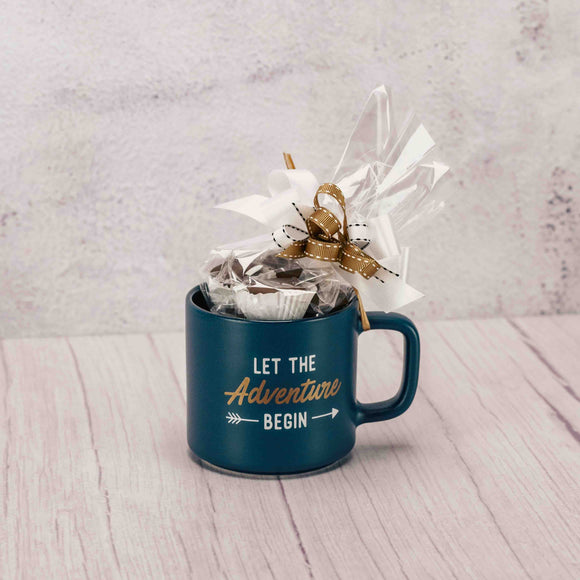 A mug that reads 'Let the adventure begin' is filled with a half pound of our assorted milk chocolates