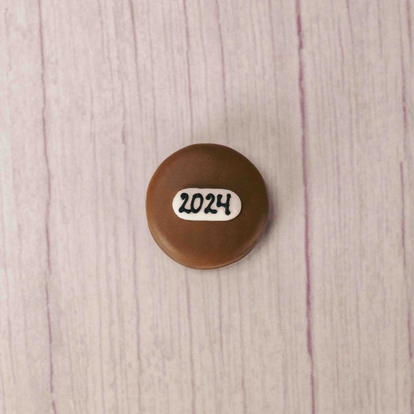 Milk chocolate covered Oreo with 2024 written in icing