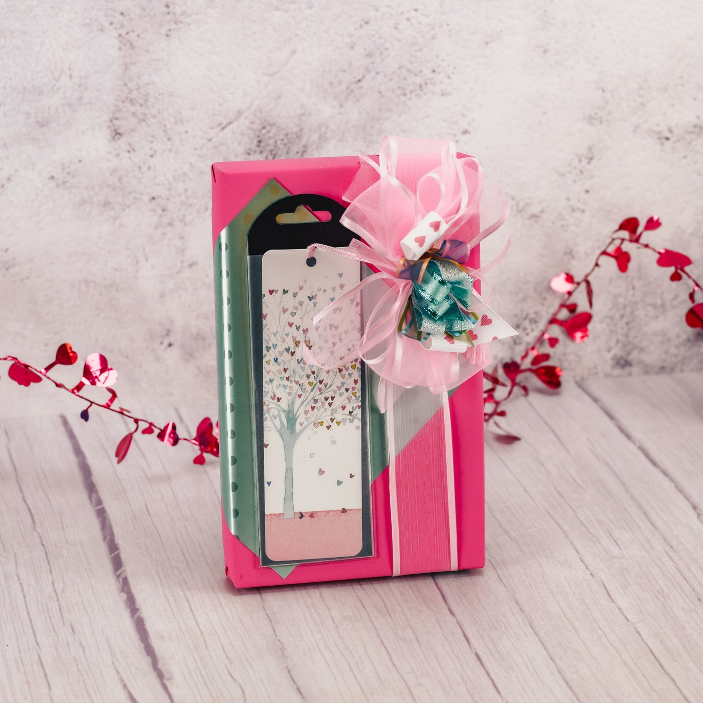 a one pound box of assorted chocolates wrapped and topped with a tree of heart designer bookmark. Choose milk or milk and dark chocolate assortment.