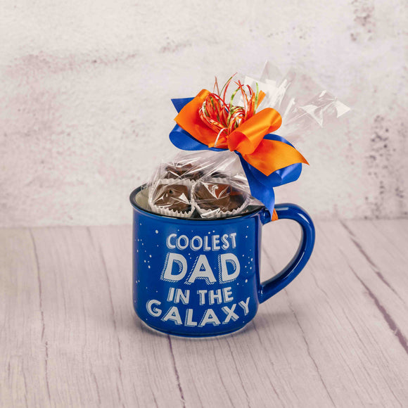 a blue mug filled with a half pound of assorted chocolates reads 'coolest dad in the galaxy'