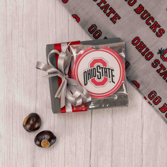 One Ohio State ceramic car coaster sits atop a sampler box of our exquisite Assorted Chocolates and is wrapped and tied in OSU colors of scarlet & gray. The car coasted is to absorb moisture and condensation and features a finger notch for easy removal.