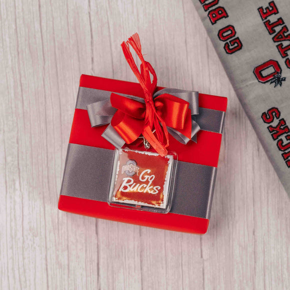 a sampler box filled with Buckeyes and topped with an Ohio State keychain that reads 'Go Bucks' on top