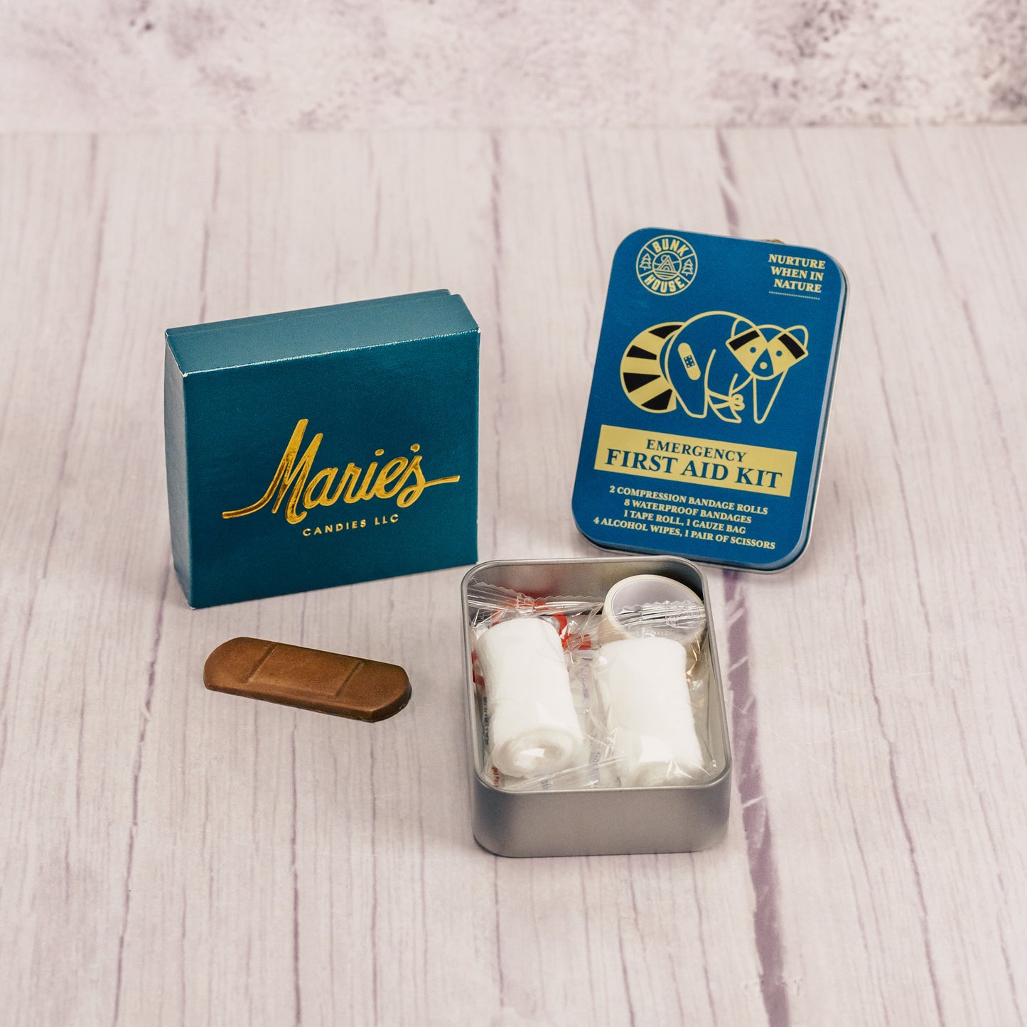 a compact first aid kit is packaged with a sampler and a chocolate bandage
