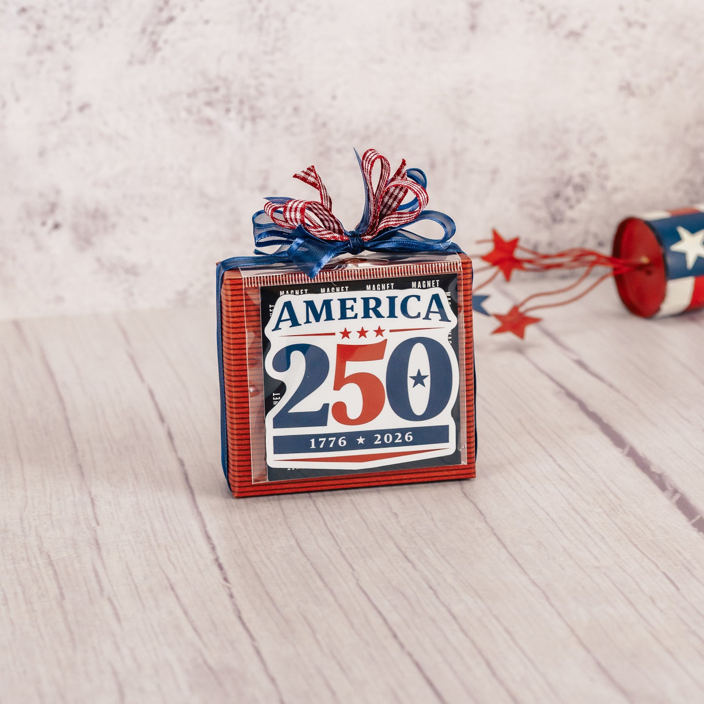 a sampler box of assorted chocolates is wrapped and topped with a magnet that reads 'American 250 - 1776-2026'