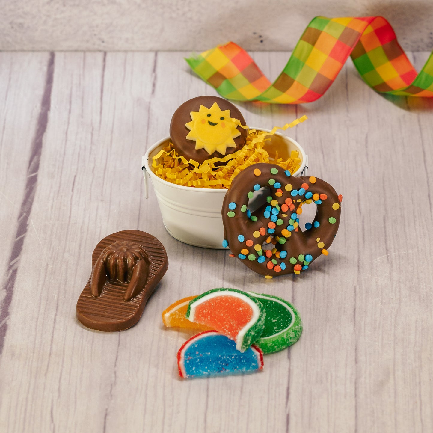 a small white metal bucket is filled with sweet summer treats!
