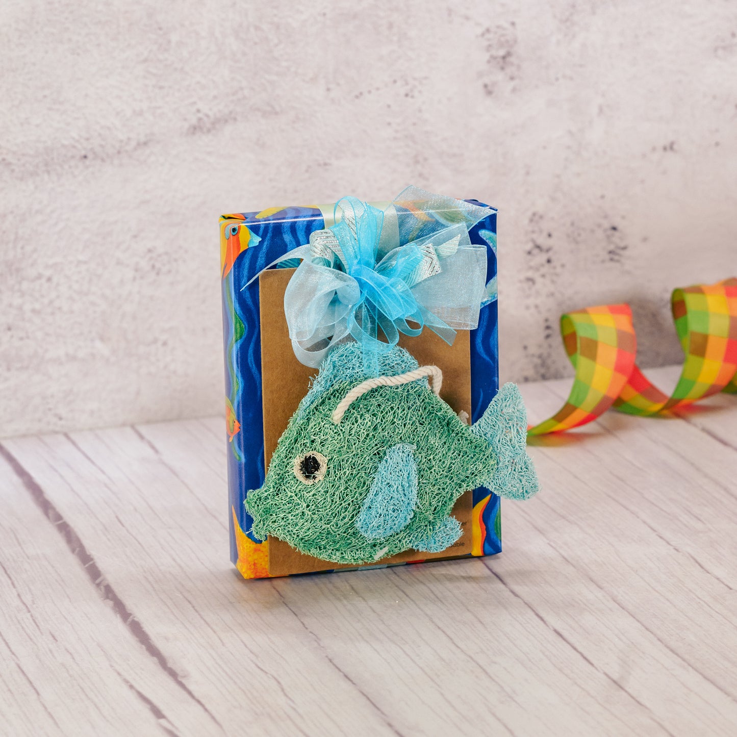 a half pound box of our assorted chocolates is wrapped and topped with a fish kitchen loofah scrubbie