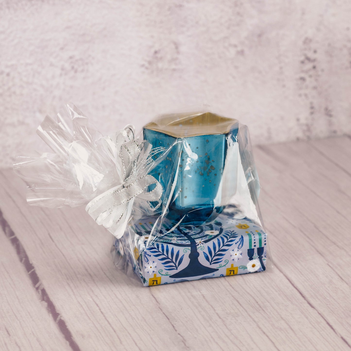 A glass Star of David candle holder is packaged with a sampler box of assorted chocolates and comes with a battery operated tealight.