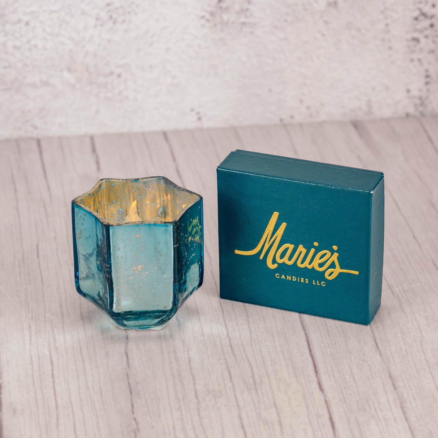 A glass Star of David candle holder is packaged with a sampler box of assorted chocolates and comes with a battery operated tealight.