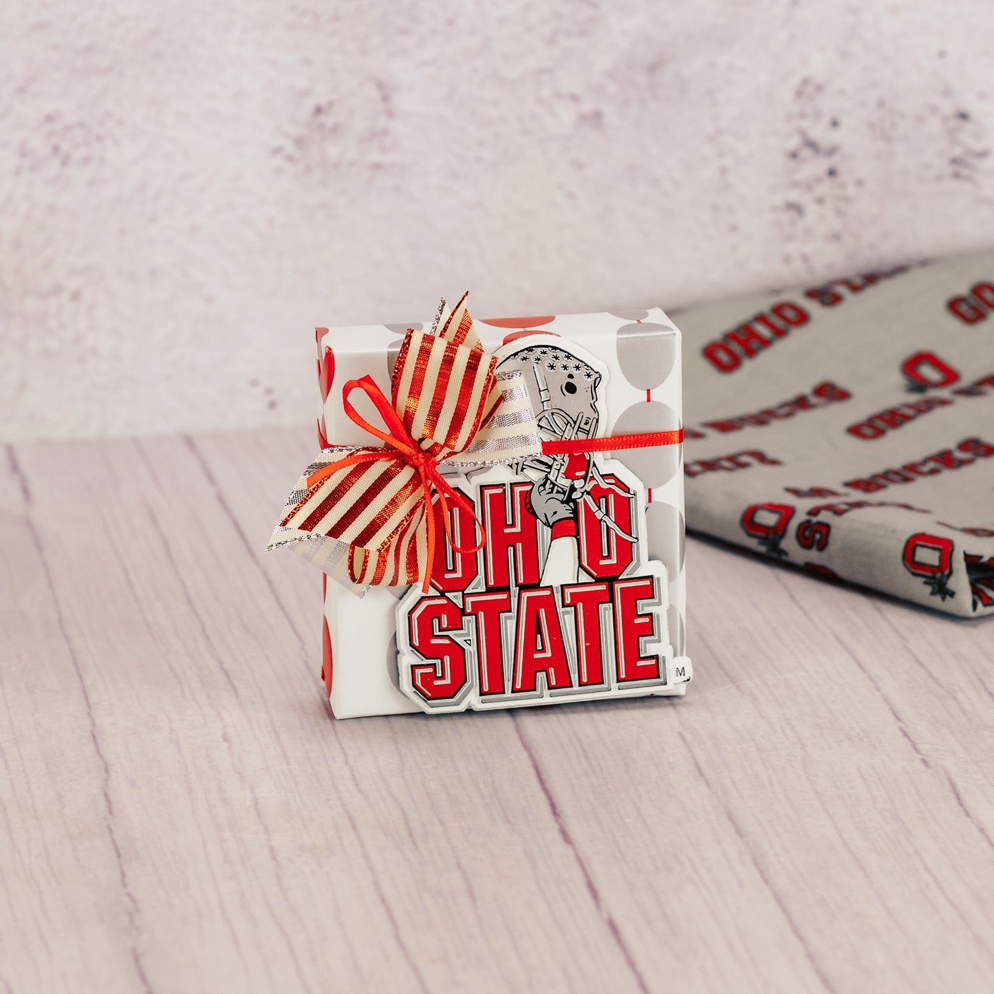 a sampler box of assorted chocolates wrapped and topped with an Ohio State helmet magnet