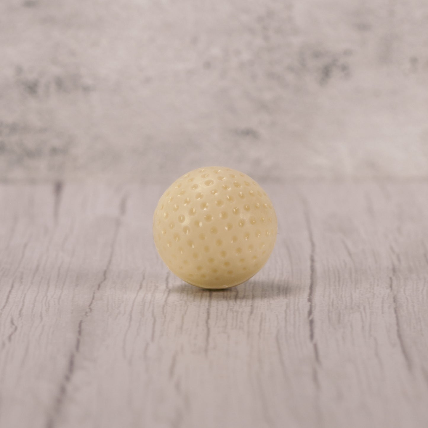 Solid white coating golf ball packaged with a real golf tee.