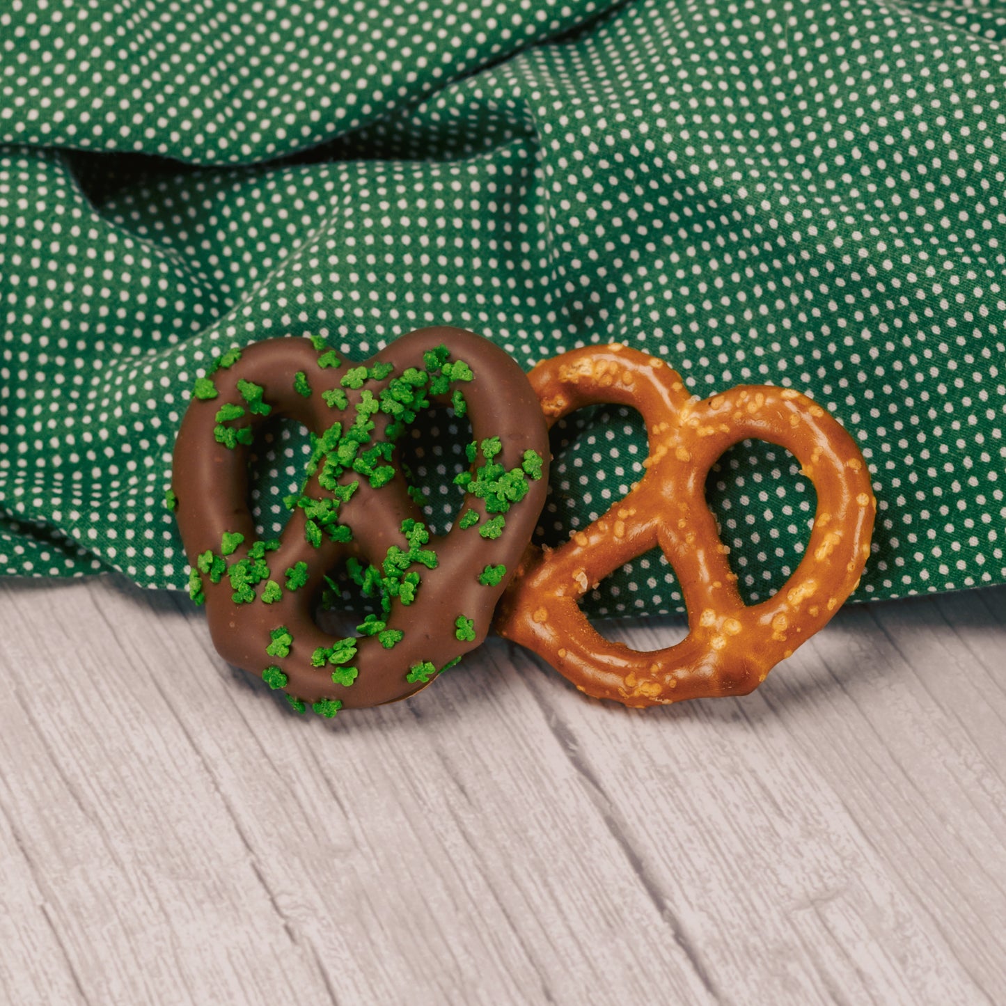 a jumbo pretzel covered in milk chocolate and sprinkled with clover sprinkles for St. Patrick's Day