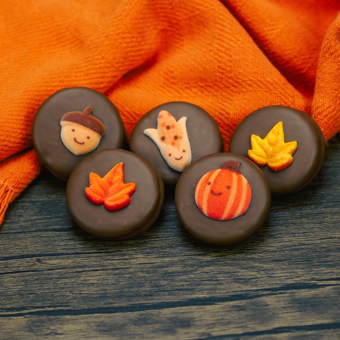 Oreo cookie dipped in milk chocolate with fall decoration on top.