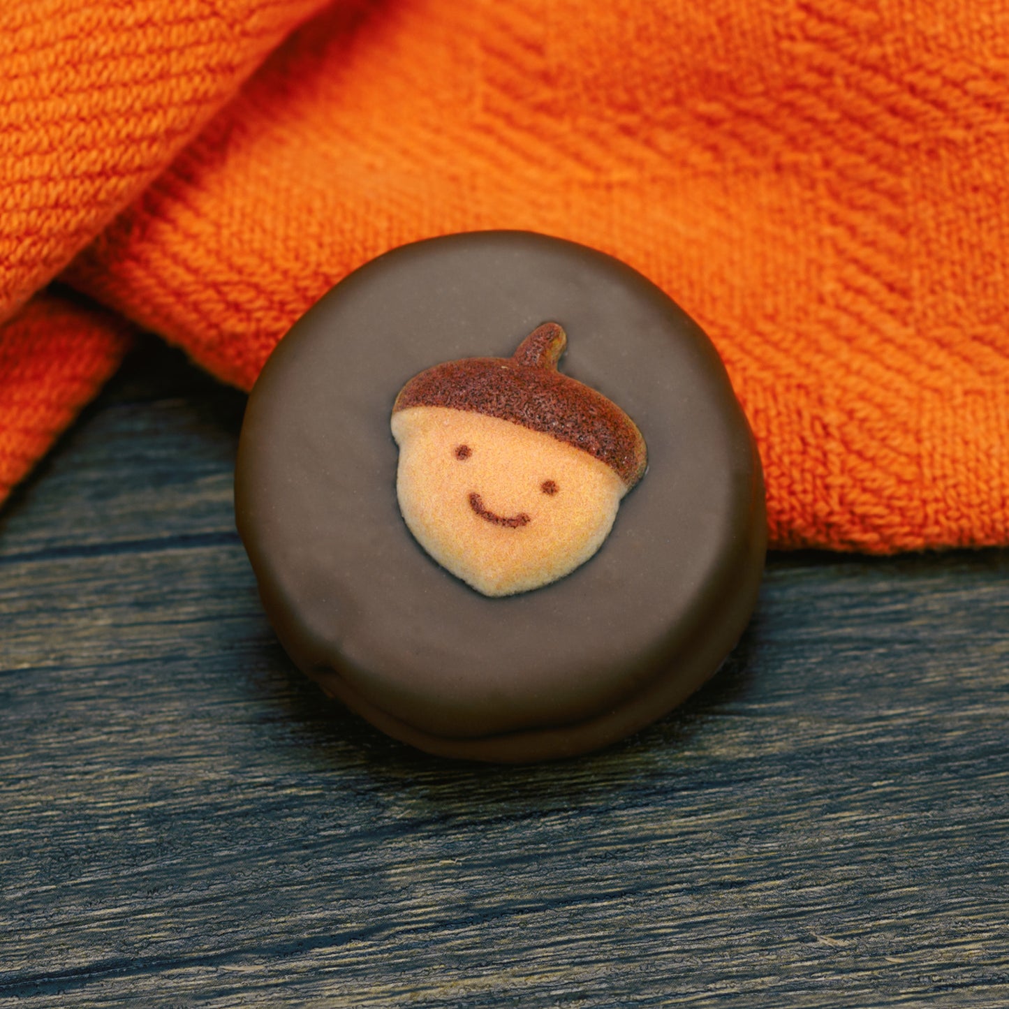 Oreo cookie dipped in milk chocolate with fall acorn face decoration on top.