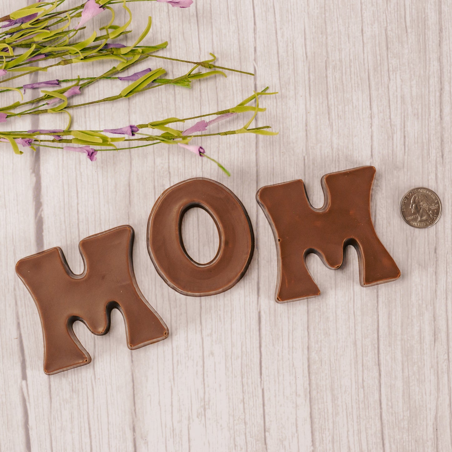 Milk chocolate letters M, O, M are placed in a box with a clear lid and ready to be presented to the best mom for mother's day! We can gift wrap the box.