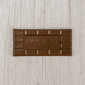 Milk chocolate, dark chocolate or white coating molded into a bar that says "Marie's"