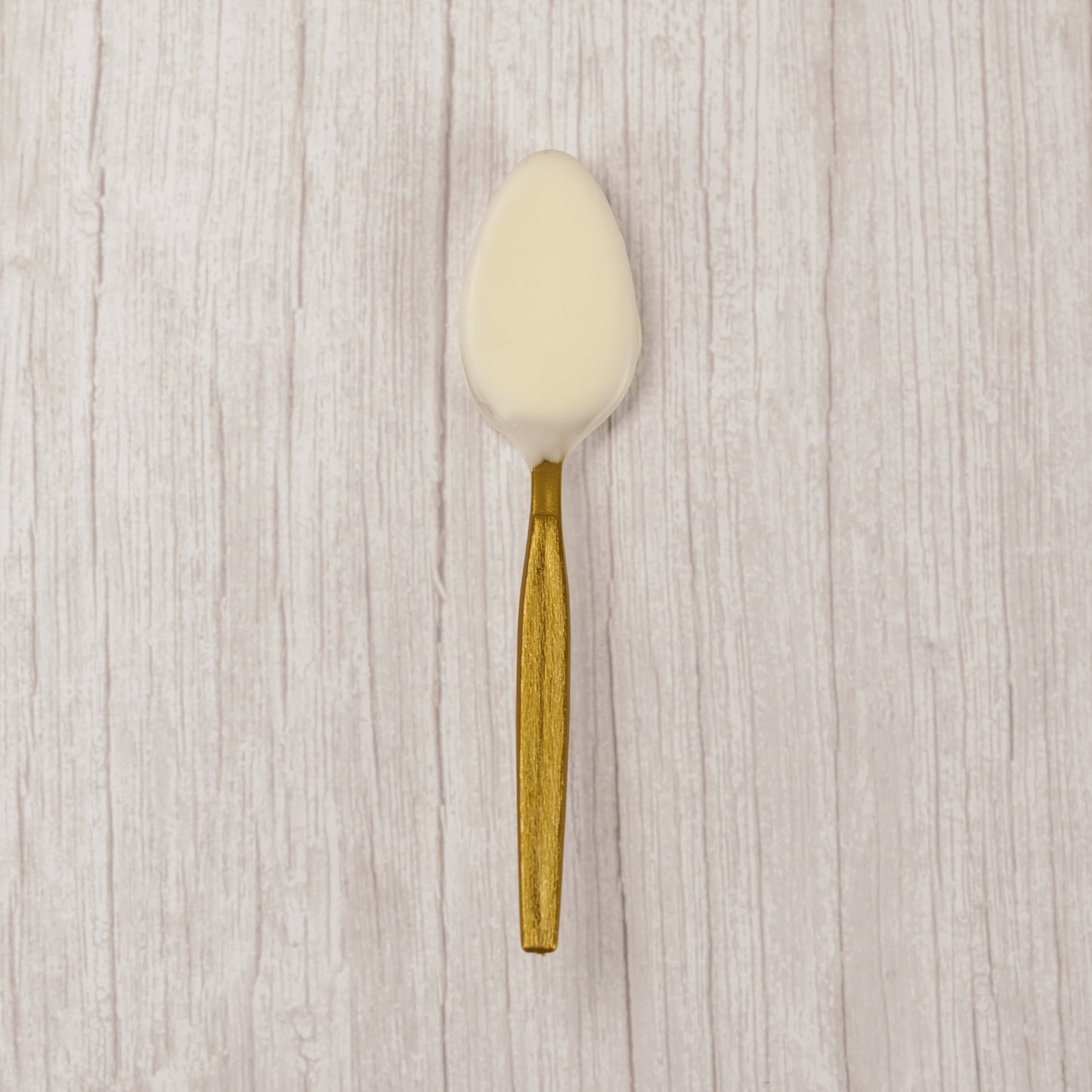 A plastic spoon dipped in white coating. Individually wrapped.