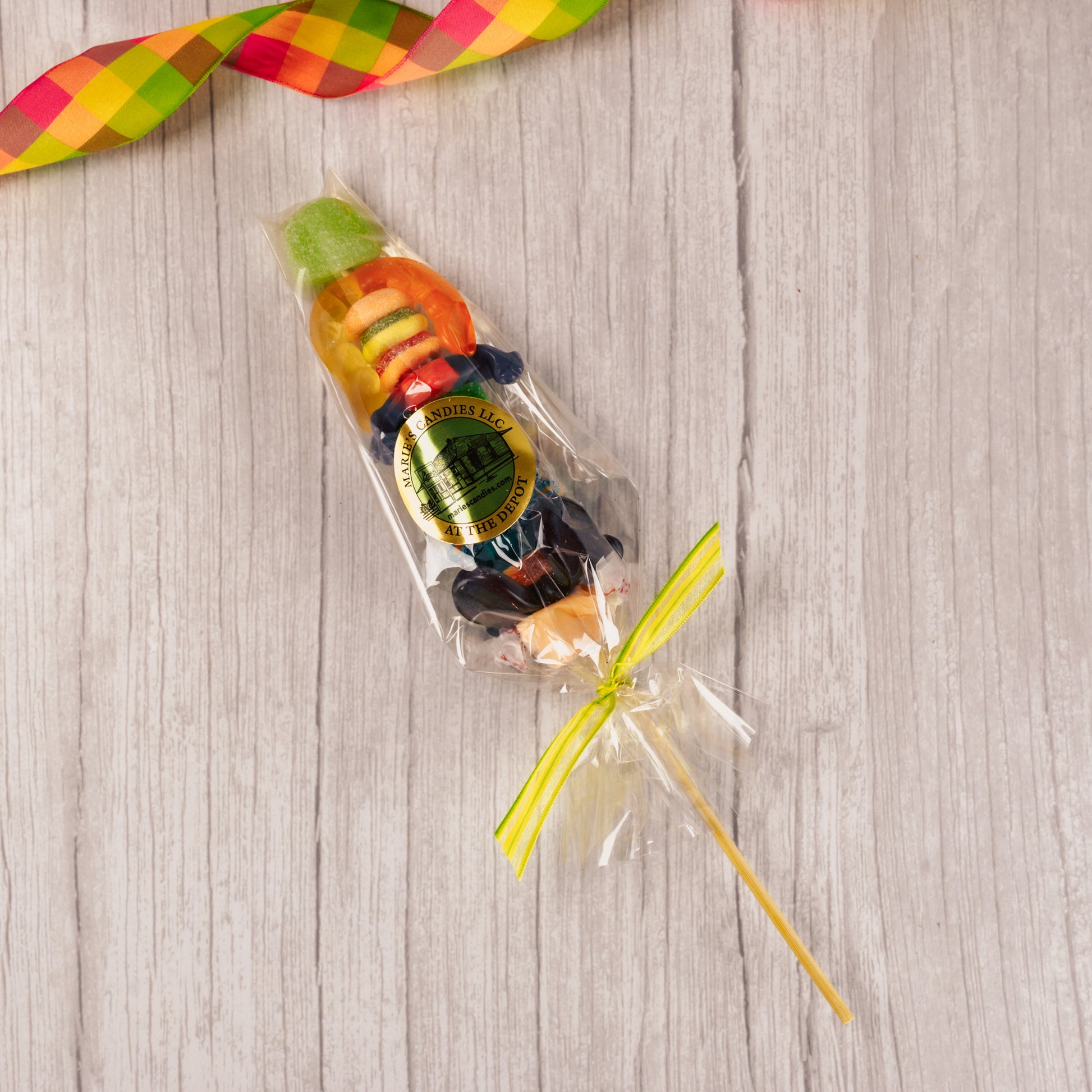 a kebob of assorted gummi pieces like: fruit slices, frogs, worms, cherries and more!