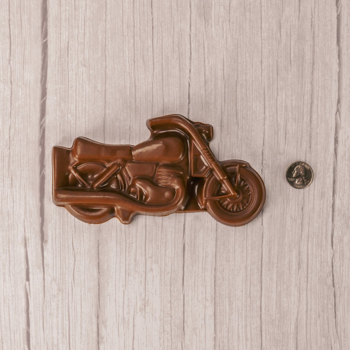 A motorcycle made of smooth milk chocolate is placed in a box with a clear lid, ready to be given as a gift to all of your motorcycle enthusiasts!