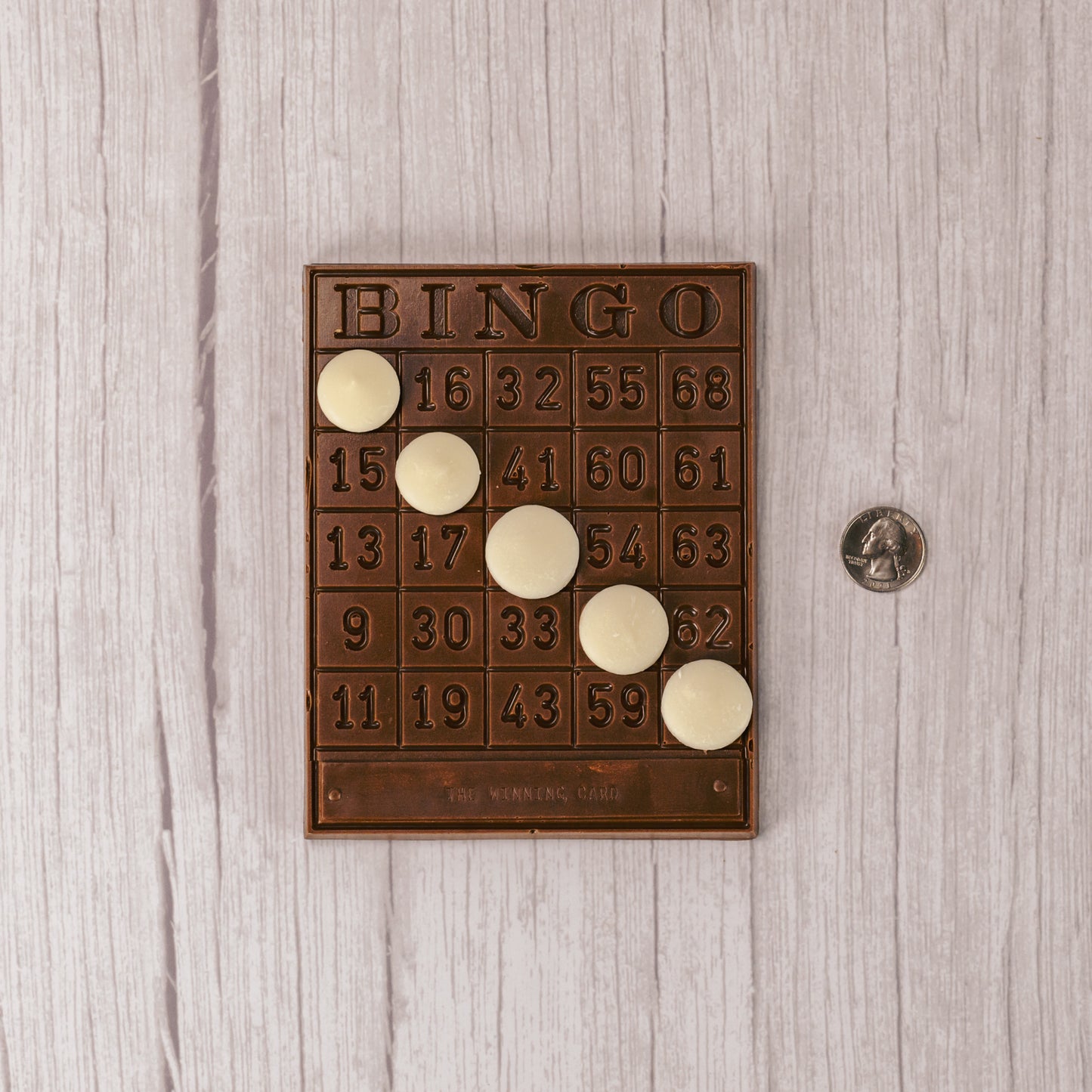 a milk chocolate bingo board with white coating discs to cover spots