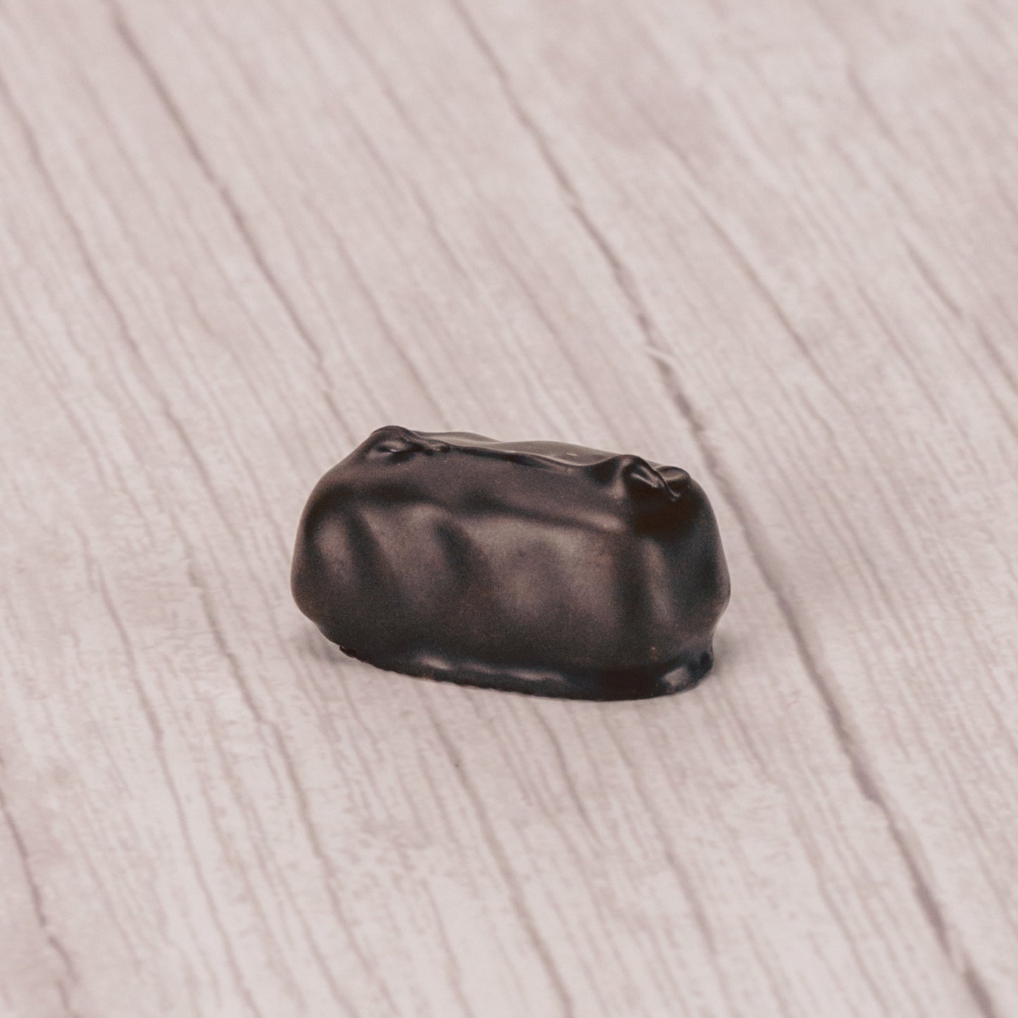 Raspberry jelly center dipped in dark chocolate in a pound box.