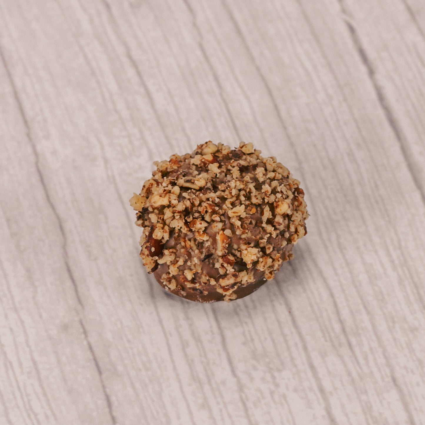 a pound box of rich vanilla cream centers covered in milk chocolate and topped with crushed pecans