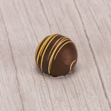 milk chocolate hazelnut truffle with yellow drizzle icing on top