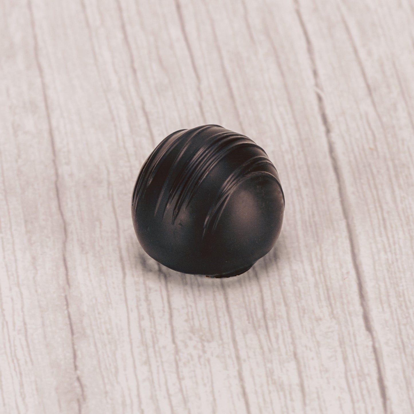 dark chocolate champagne truffles with dark chocolate icing drizzle on top.