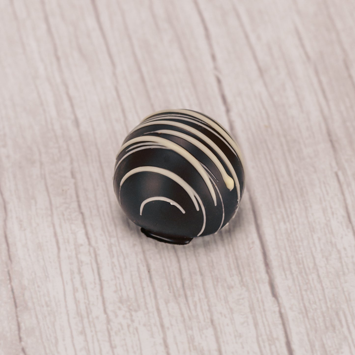 dark coffee truffle with white icing drizzle on top