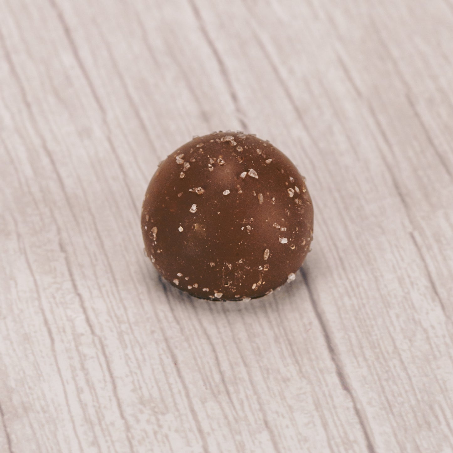 milk chocolate sea salt truffle with sea salt sprinkles on top