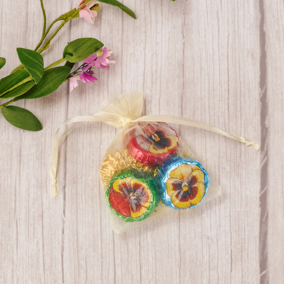 Enjoy passing out a small treat to your friends and family this spring. An ivory gauzy pouch is filled with five silky Milk Chocolate Foil Pansies, making lovely party favors or gifts for any spring occasion.    