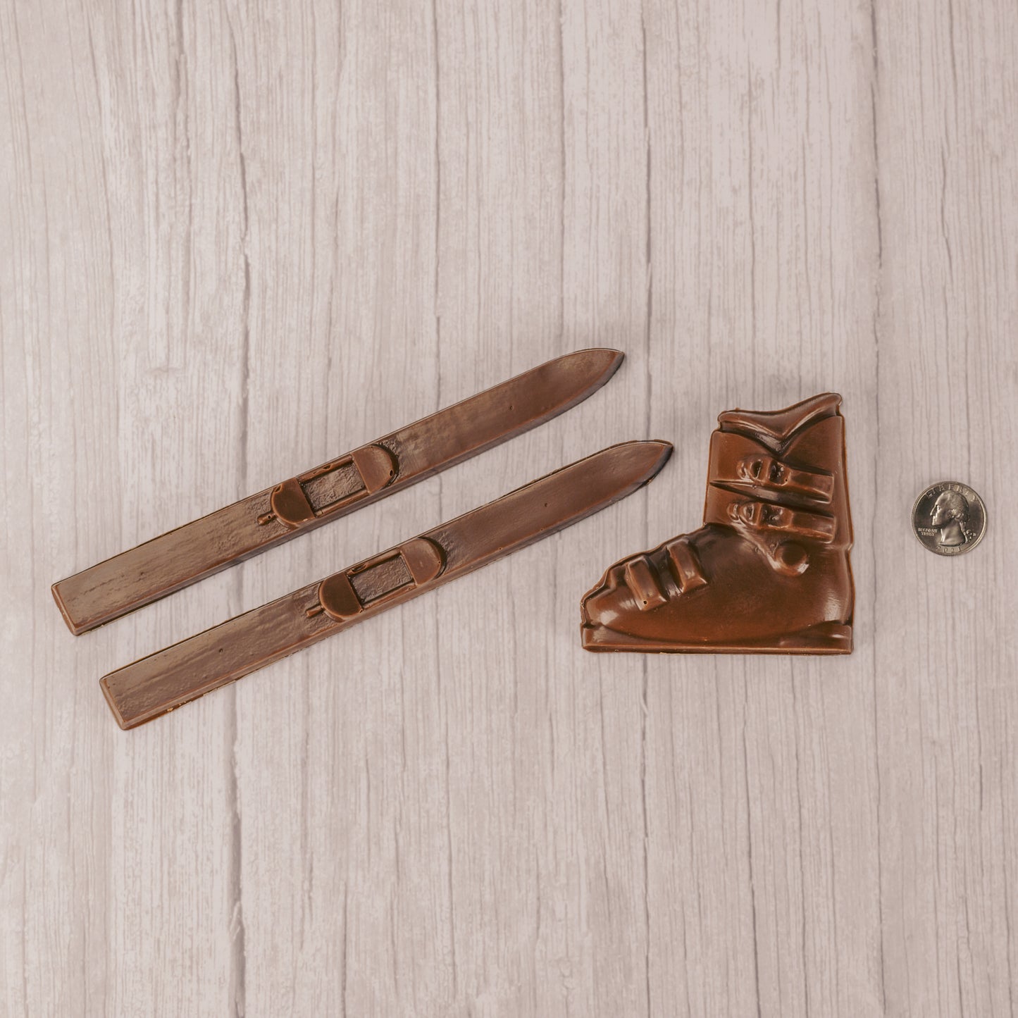 a pair or snow skis and a boot in smooth milk chocolate. comes packaged in a box with a clear lid.