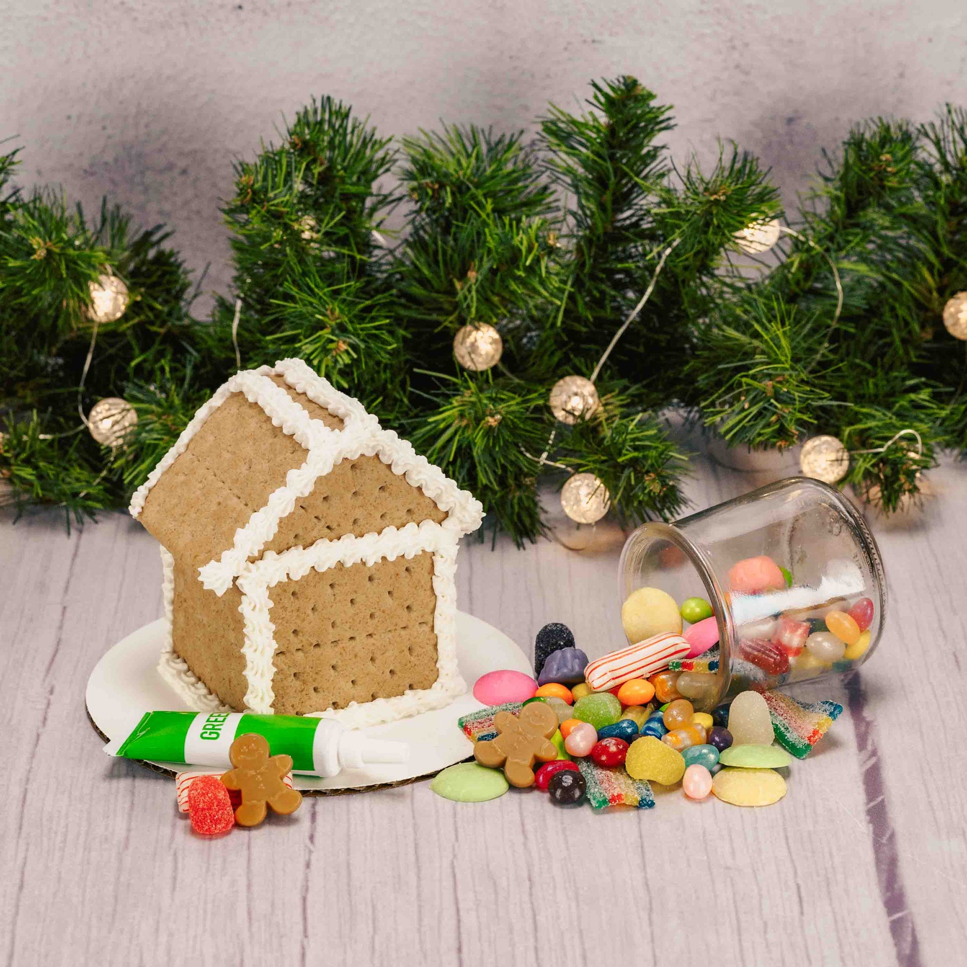A ready-to-decorate gingerbread house kit featuring a fully assembled gingerbread house; made out of Graham Crackers, assorted colorful candies, and tube of icing (colors vary) —everything you need to add your own festive decorations with no building required. For in-store pickup in West Liberty, Ohio ONLY!