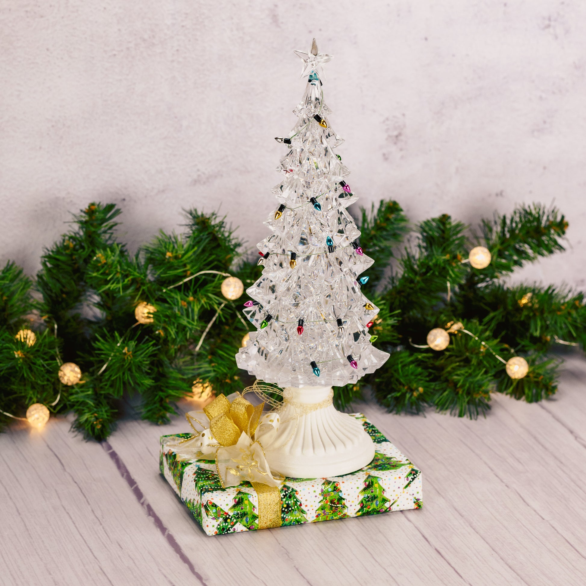 This 12-inch lighted tree features swirly glitter inside comes packaged with a half pound box of Assorted Chocolates.