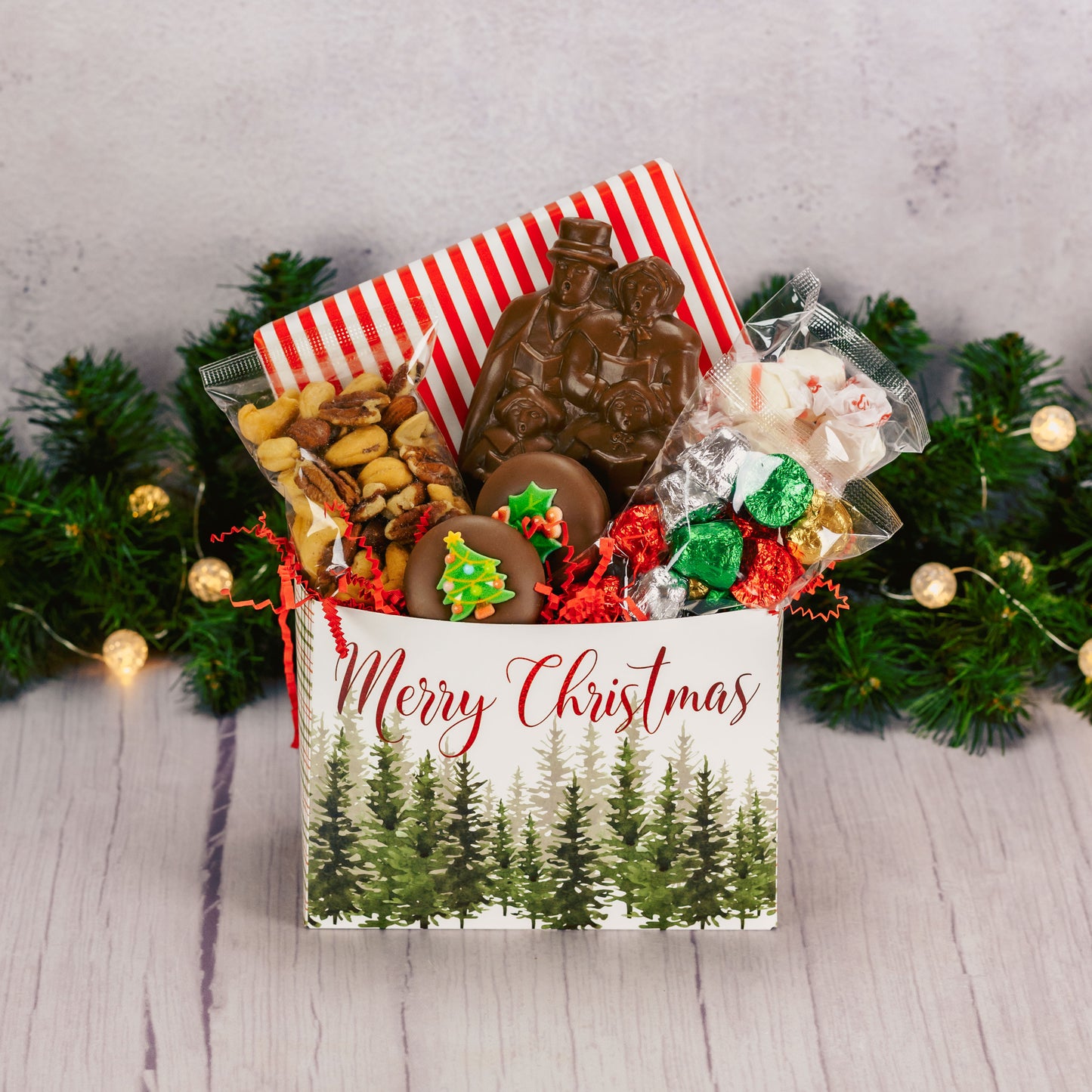 a small gift basket box that reads 'Merry Christmas' is filled with sweet seasonal treats for a large crowd to enjoy!