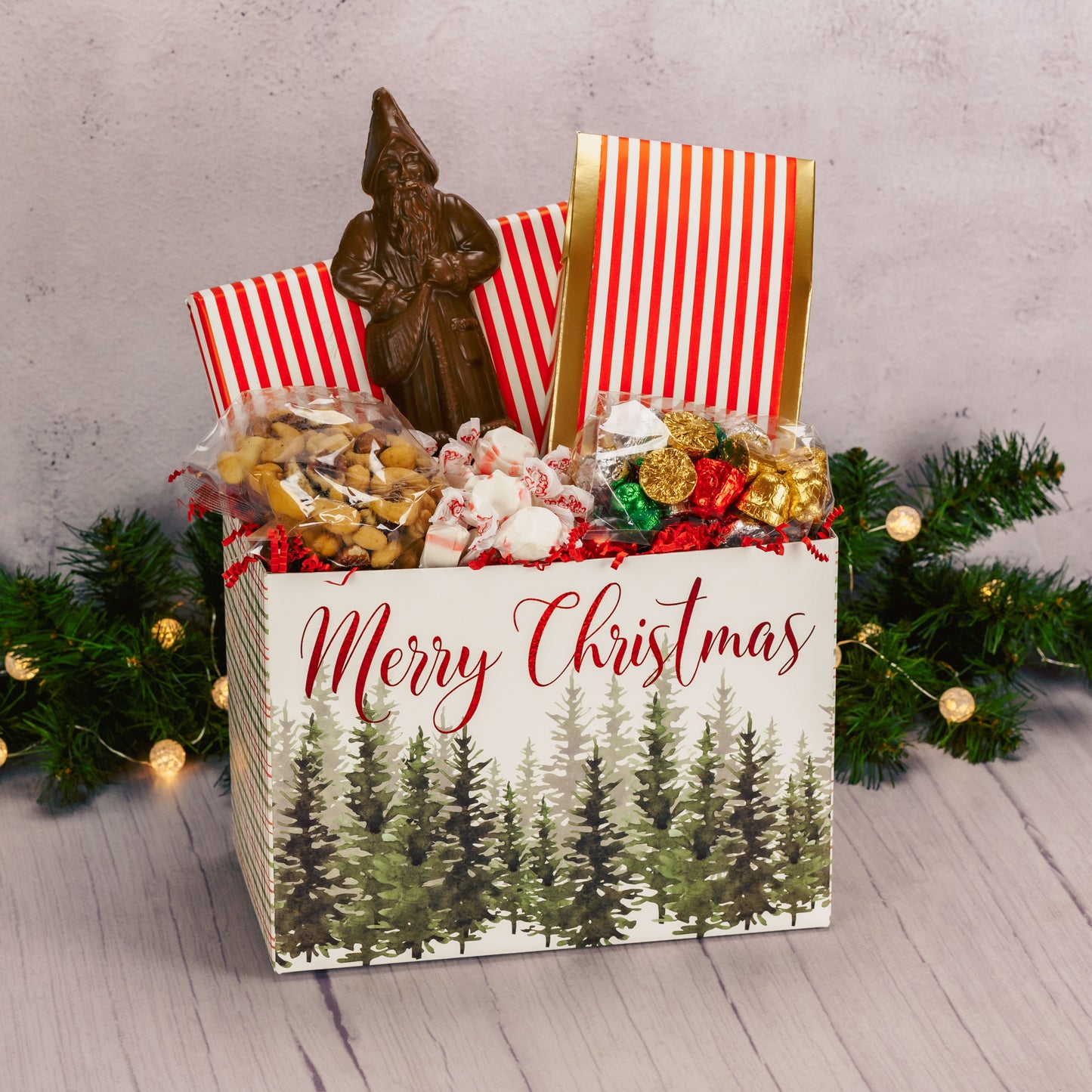 a large gift basket box that reads 'Merry Christmas' is filled with seasonal sweet treats for a large crowd to enjoy.