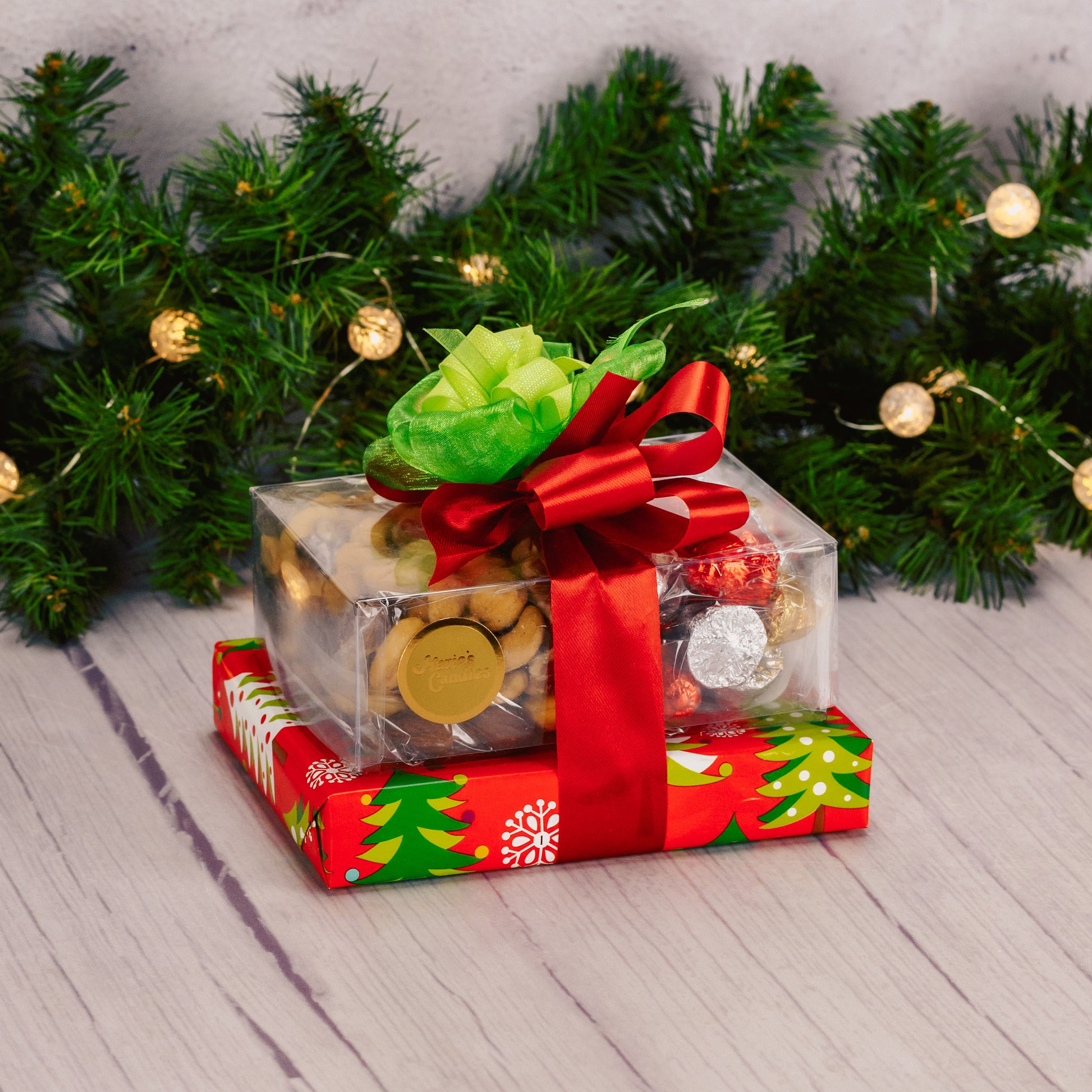 a small gift stack wrapped and tied in traditional red and greens is a lovely gift of appreciation this holiday. Includes an assorted box of chocolates, roasted & salted mixed nuts and milk chocolate foil bells. 