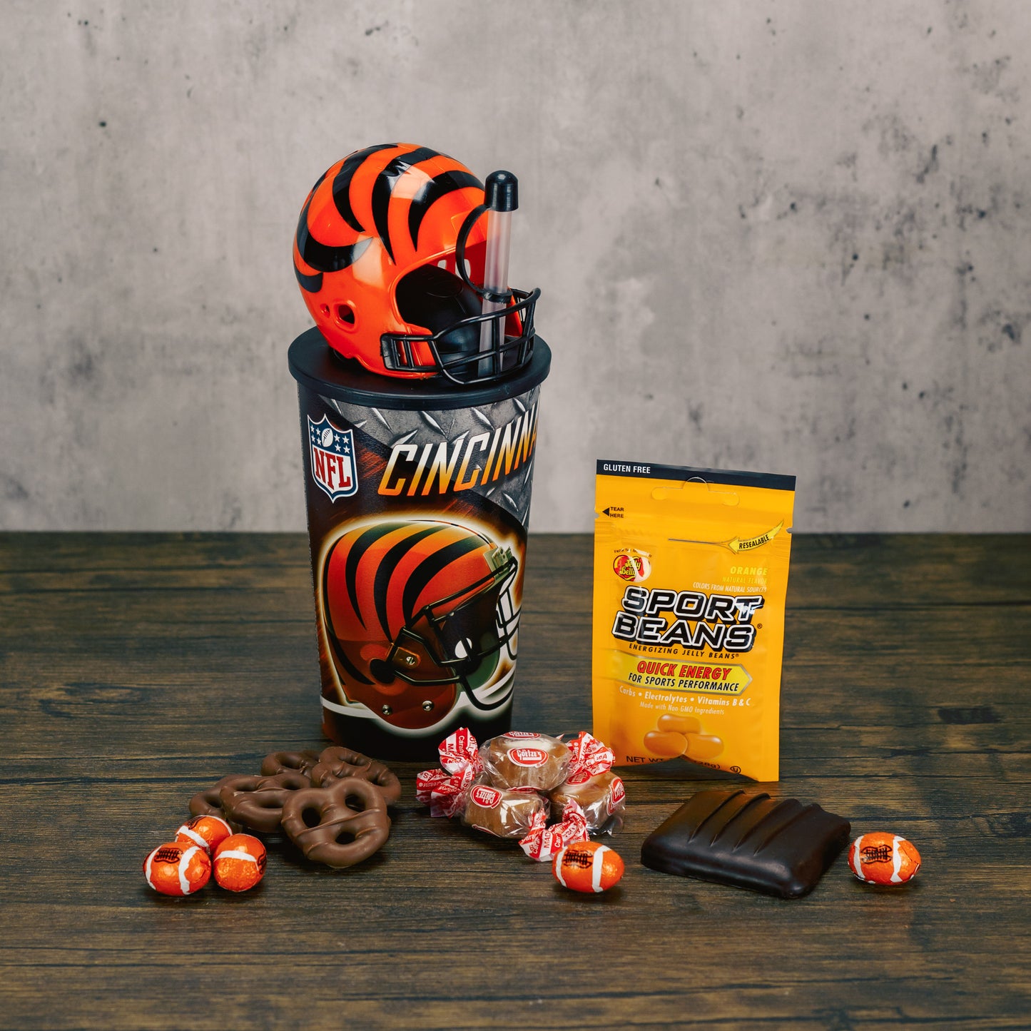 A Cincinnati Bengals NFL official cup with straw and detectable football helmet cup is filled with sweet treats. 