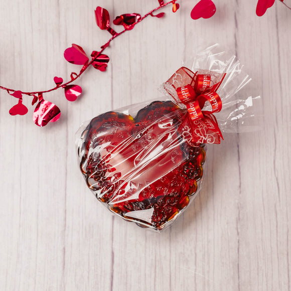 a red Mosser Glass heart shaped box is filled with 4 of our wonderful pieces of candy. 