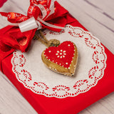 a half pound box of assorted chocolates is wrapped and topped with a wooden heart ornament