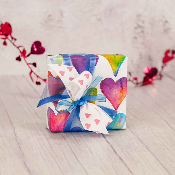 a sampler box of assorted chocolates is wrapped to impress and tied with a lovely handmade bow on top.
