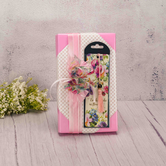 a one pound box of assorted chocolates is wrapped and topped with a peony bookmark