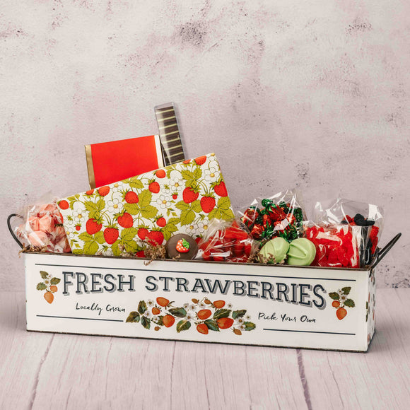 a large metal strawberry bin is filled with spectacular strawberry candy and our supreme chocoaltes
