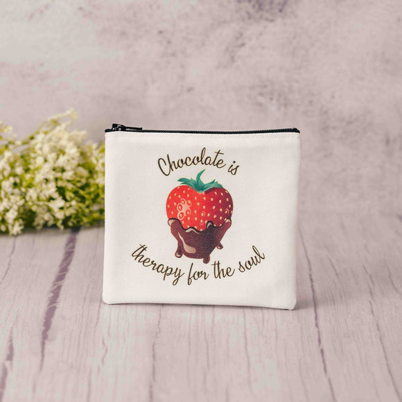 a zipper pouch with strawberries on it is filled with sweet treats  