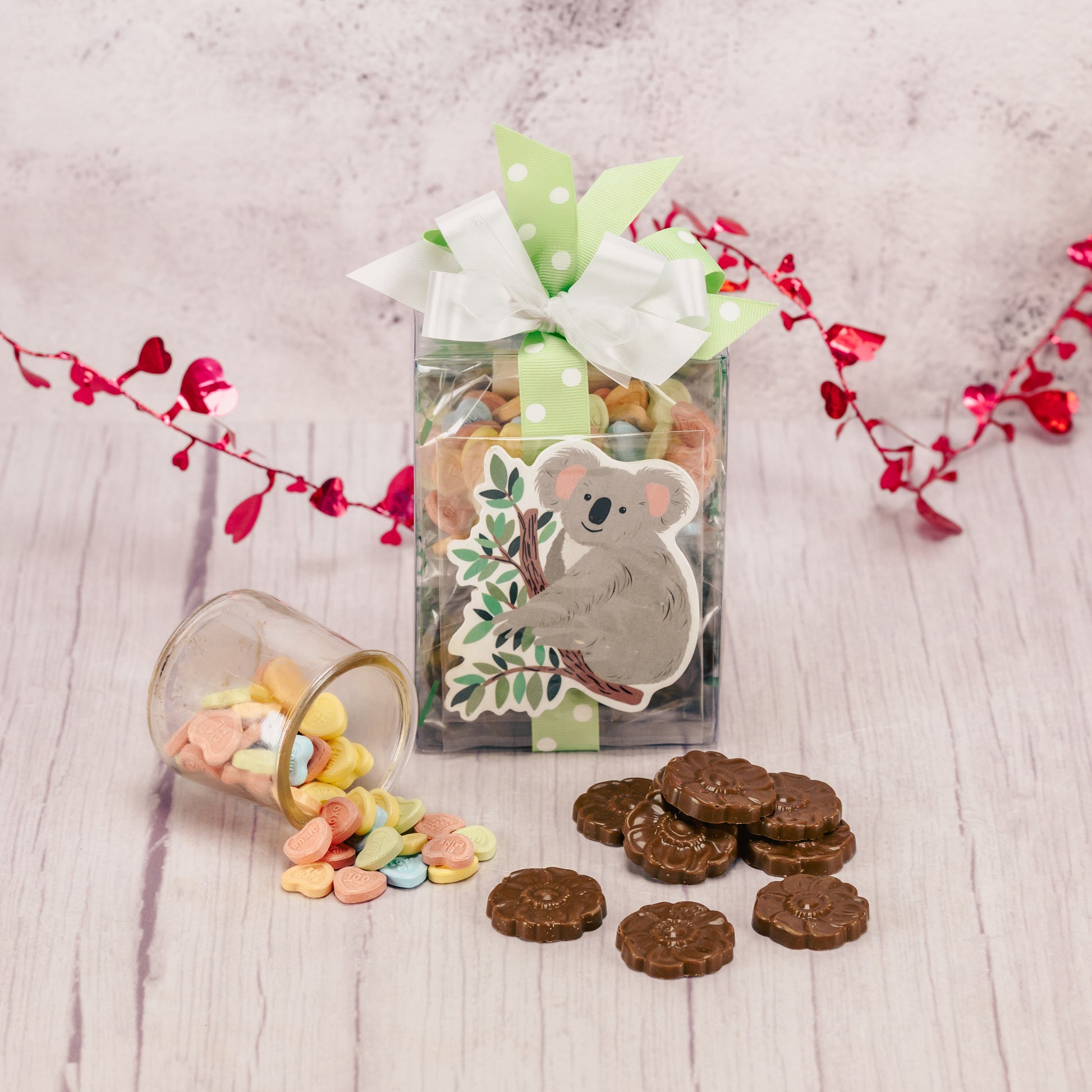 a decorative wooden koala is packaged with some sweet treats.