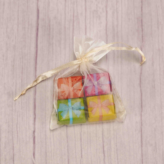 four milk chocolate everyday foil presents in an ivory gauzy pouch