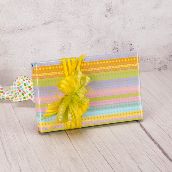 a half pound box of assorted sugar free candies is wrapped in pastel stripe paper with a handmade bow on top.