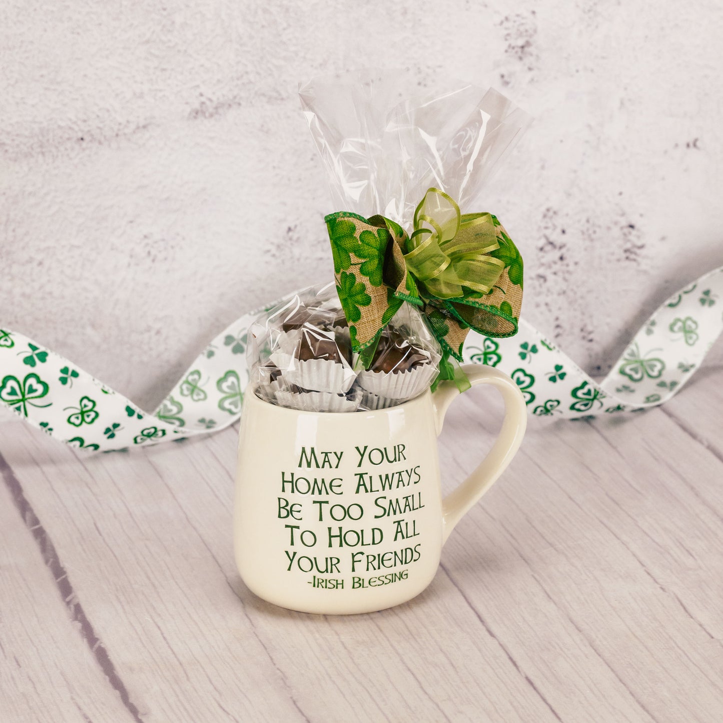 A mug with a written Irish blessing on it is filled with a half pound of assorted milk chocolates. 