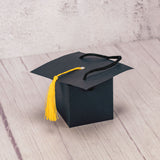 a paper foldable grad cap hat is filled with some sweet treats to celebrate the achievements.