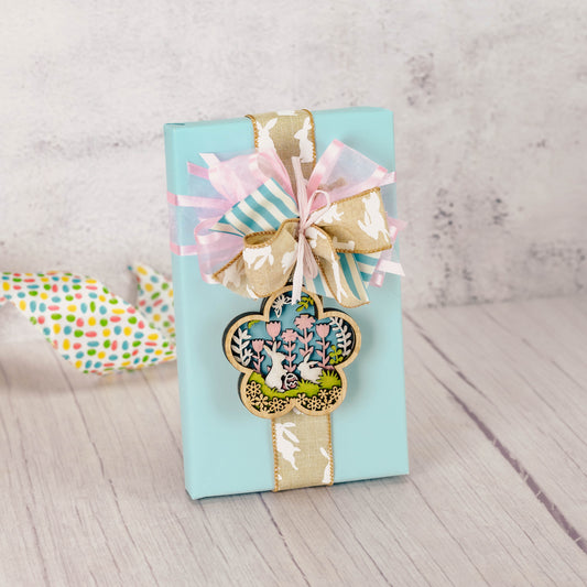 a pound box of assorted chocolates is wrapped and tied with a wooden bunny ornament/magnet