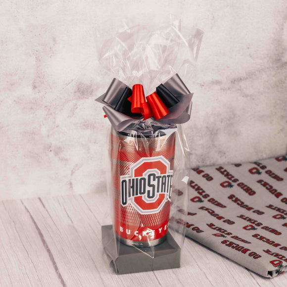 Commute to work, school or practice with this spiffy Ohio State tumbler that has the Block O on one side and Brutus on the other and is packaged with some of our favorite sweet treats like:  Scarlet & Gray Oreo  Red Jelly Belly Sports Beans  2 oz. Foil Footballs  Sampler  Packaged in a clear cello bag and tied with a handmade bow, making it the perfect gift for any Buckeye commuter! Mug is hand wash only and not recommended for the dishwasher or microwave.